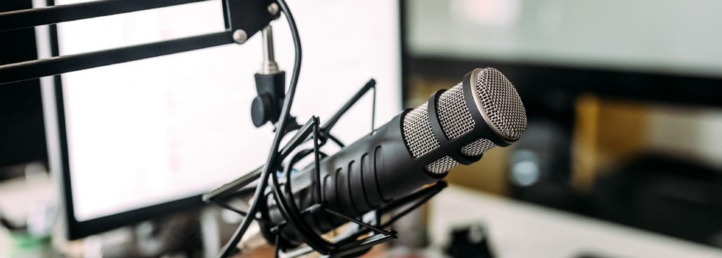 Image of a home recording studio by a computer screen.