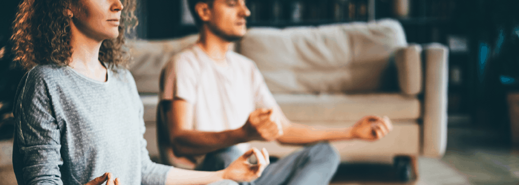 Two people sitting and meditating.