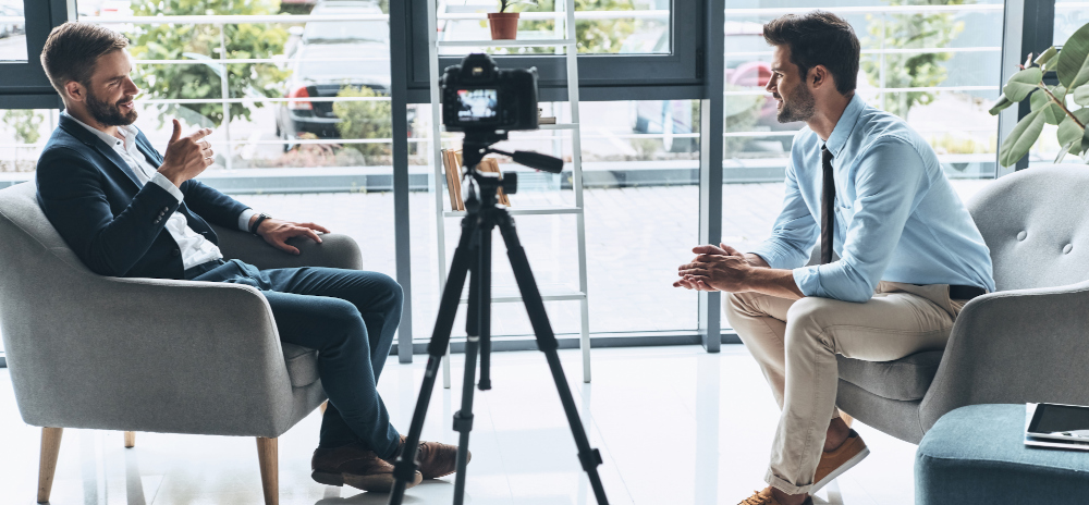 Two men discussing a topic while being recorded on camera.