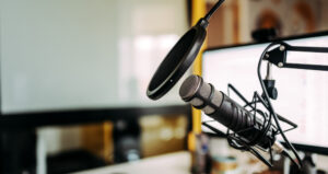 Microphone with pop filter and computer screen in background.